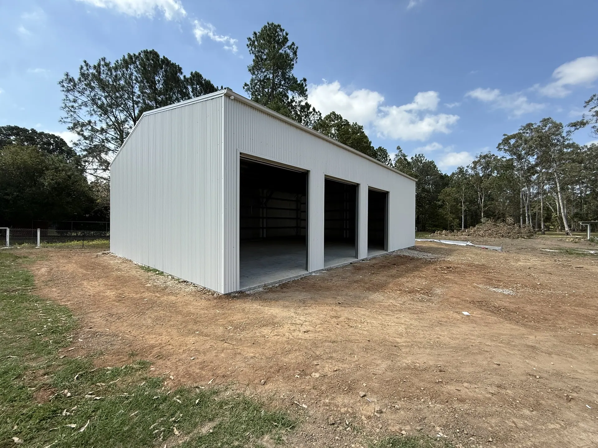 White three-bay shed on a rural block