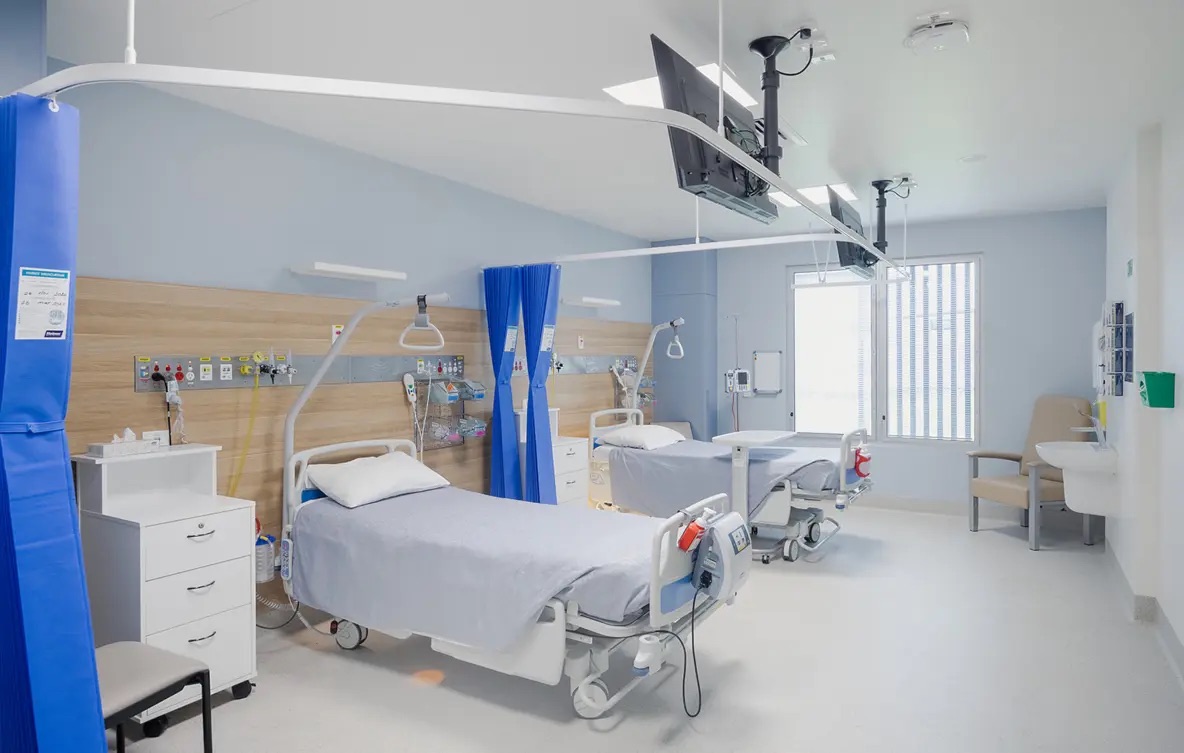 Shared patient ward at Moranbah Hospital with beds, curtains and services panels