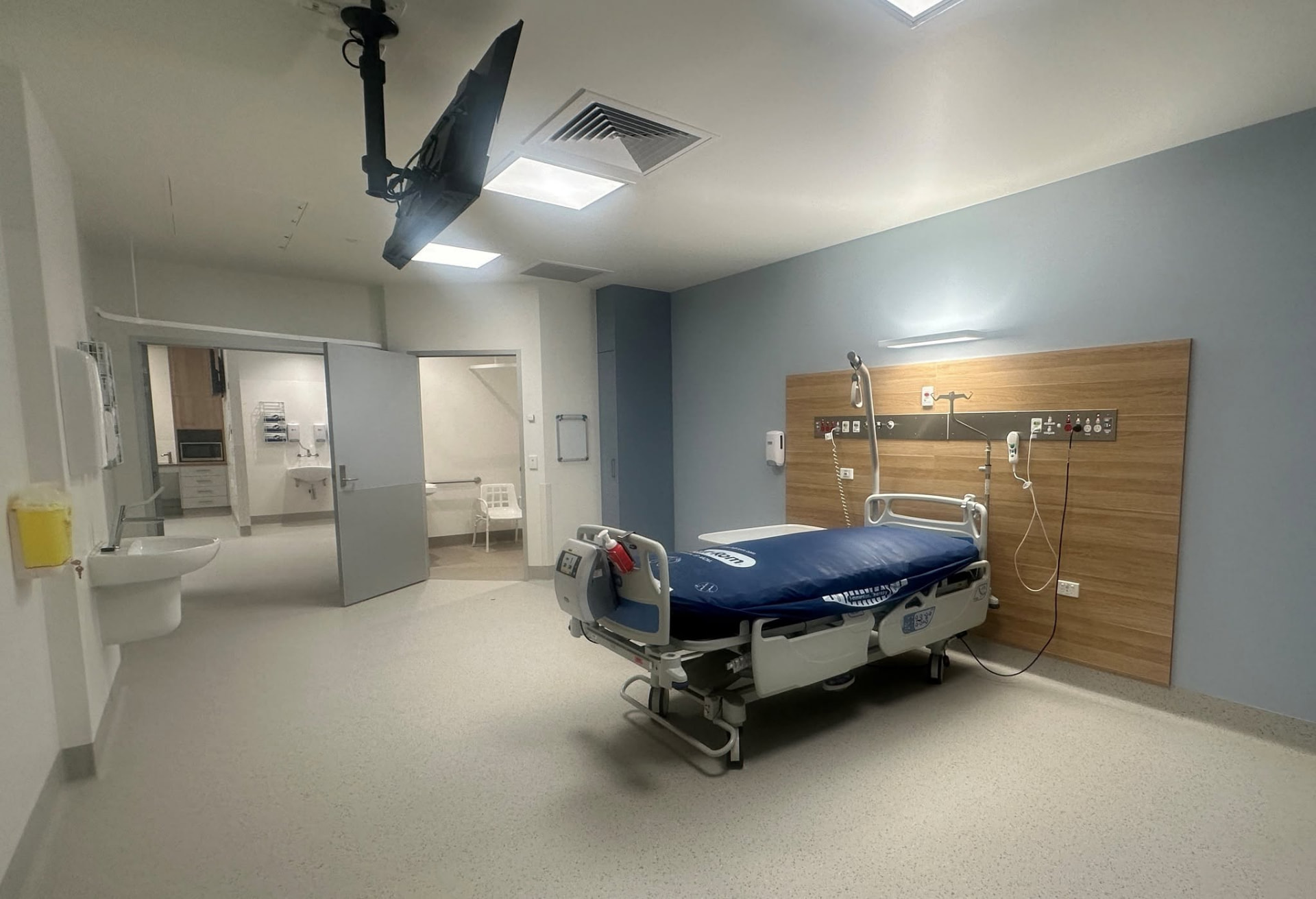 Patient room at Moranbah Hospital with timber bedhead panel and ensuite