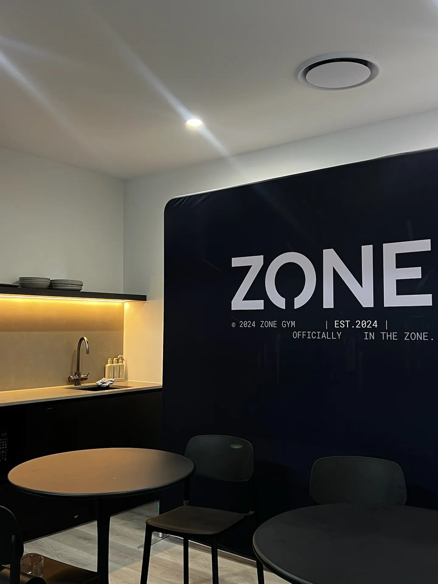 Zone branded entry wall with kitchenette and lighting